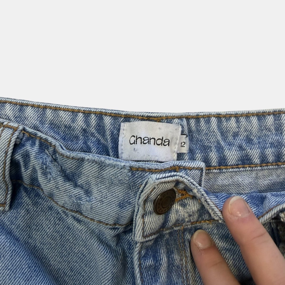 Ghanda High Waisted Light Wash Distressed Denim Shorts.